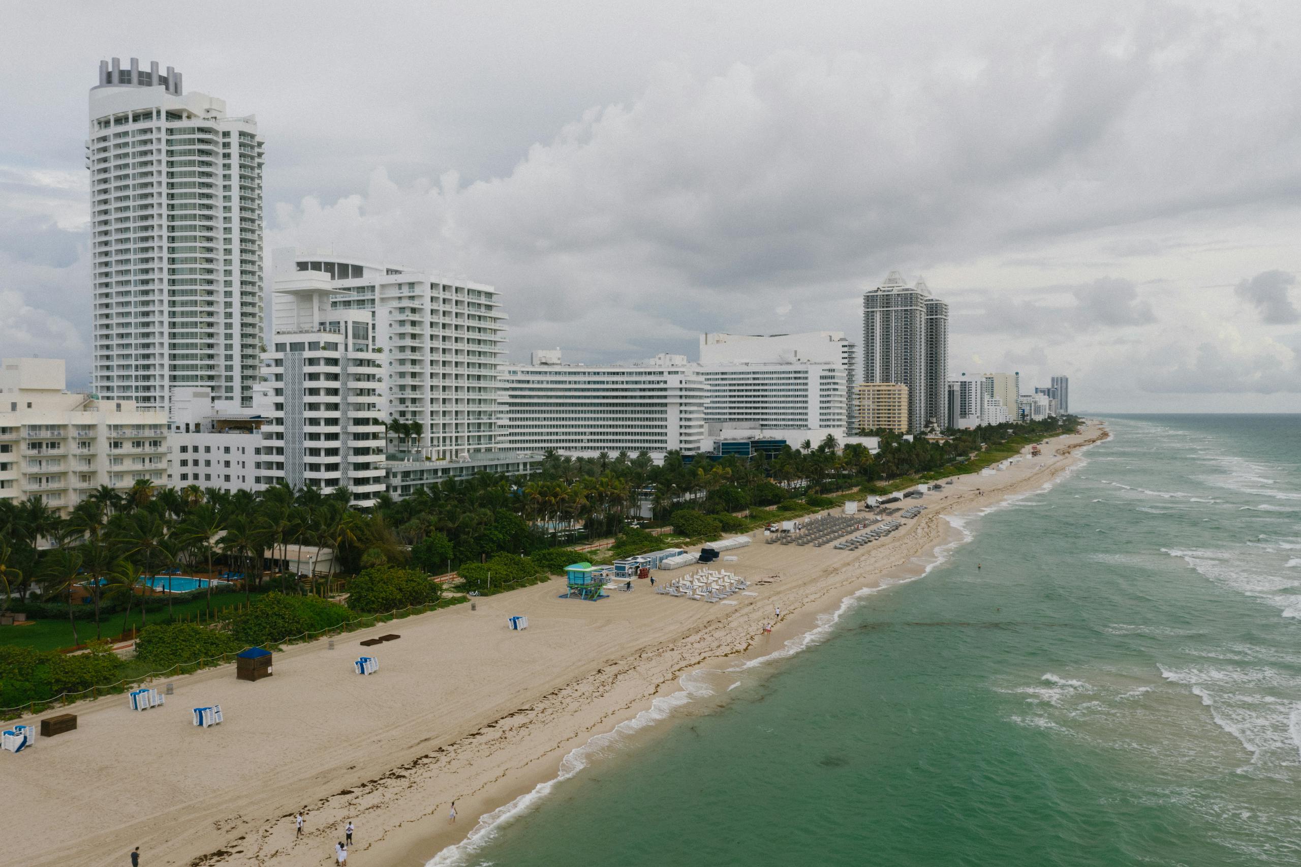Dramatic aerial photo of a coastal city's modern beachfront skyline in cloudy weather.